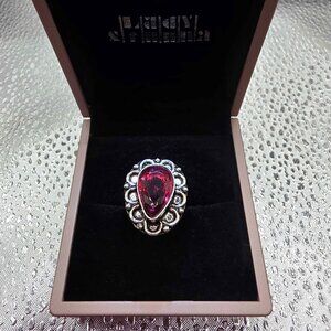 pear-shaped red gemstone, styled with ornate, gothic, or bohemian influences.